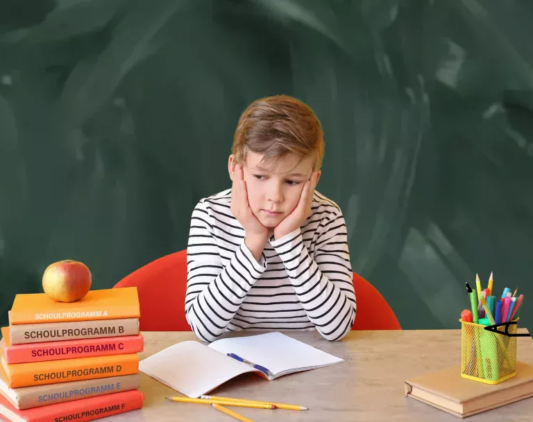 Sad little boy doing homework at table AdobeStock_401922478 tafel 0553