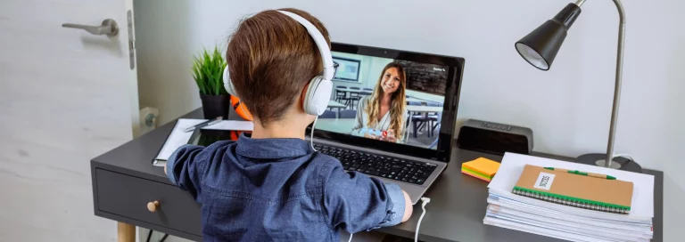 Unrecognizable boy with headphones receiving class at home with laptop AdobeStock_407437709 0443
