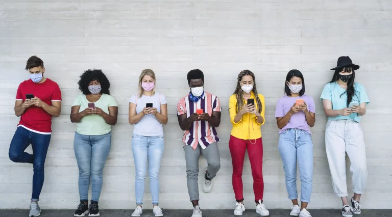 Young people wearing face mask using mobile smartphone outdoor AdobeStock_362342671 0450